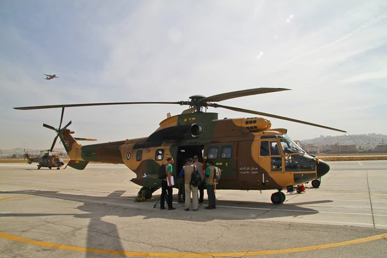 a couple of men standing next to a helicopter