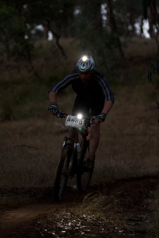 a man is riding a bicycle at night on the path