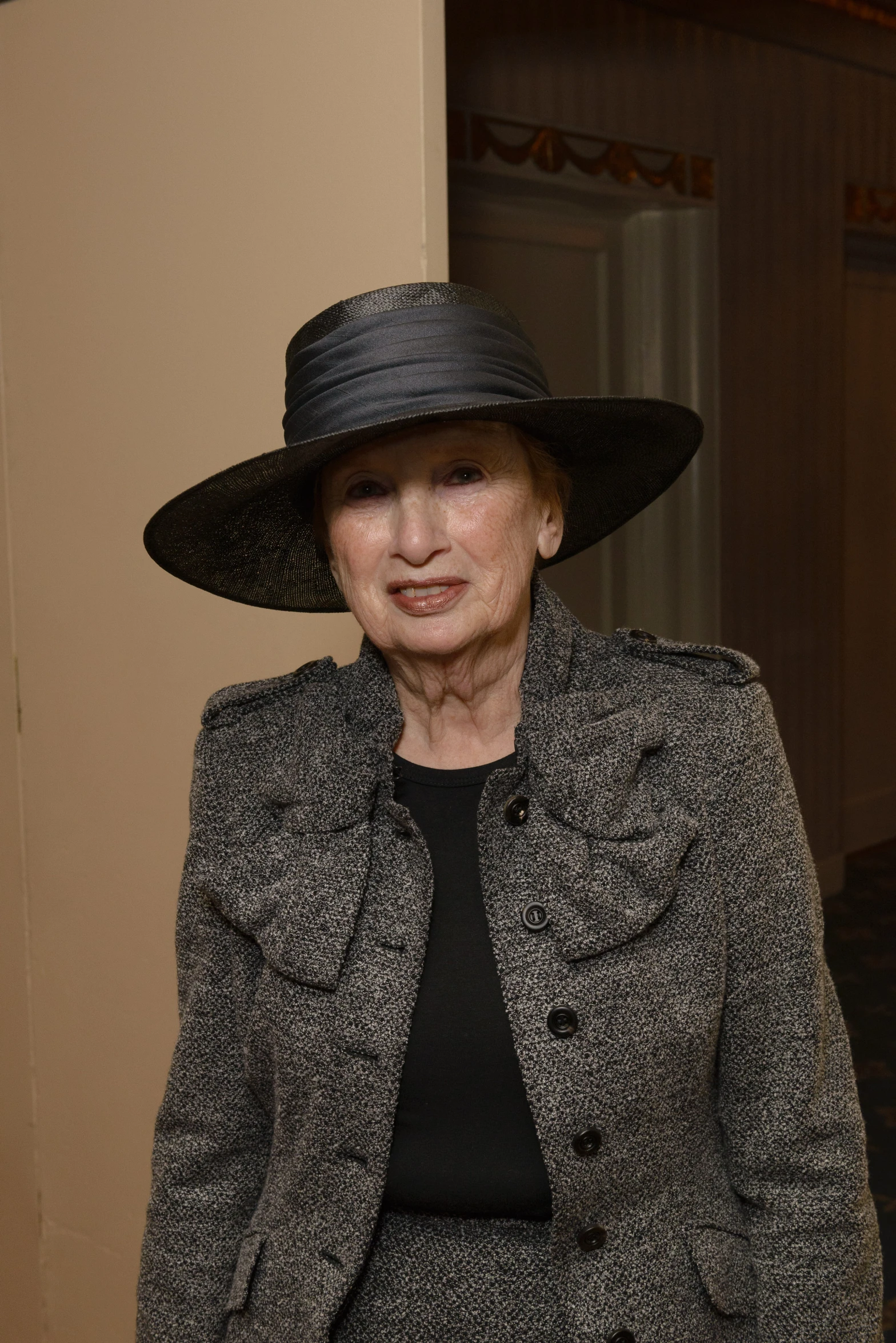 an older woman with a black hat is standing