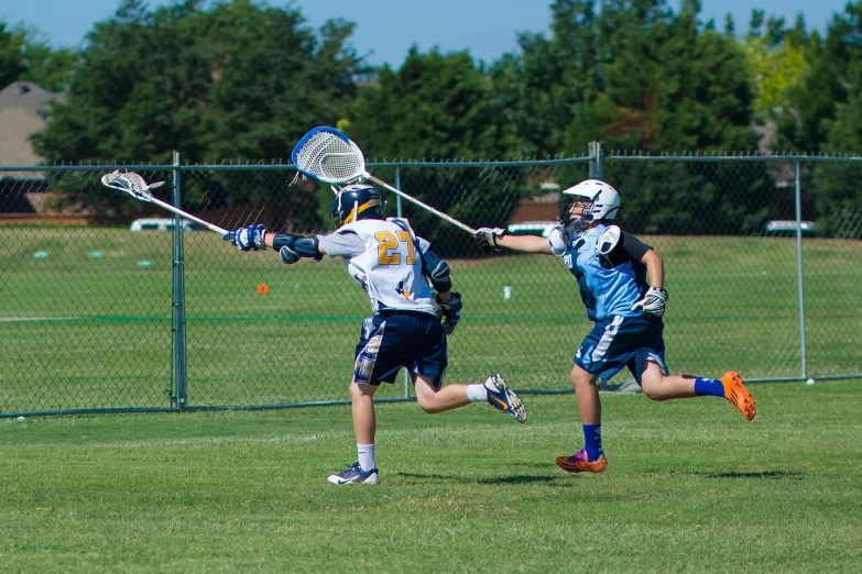 lacrosse players in action on the field playing a game