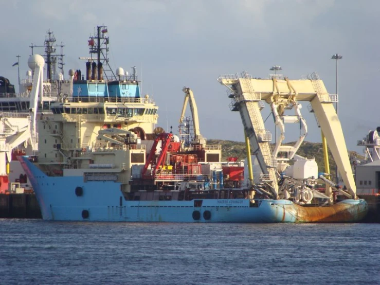 a ship docked at a port area with other ships in the background