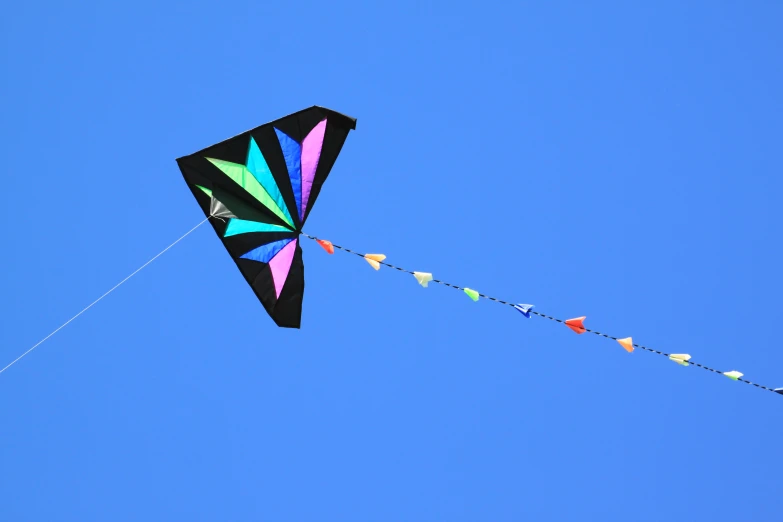 a colorful kite flying through the air on a clear day