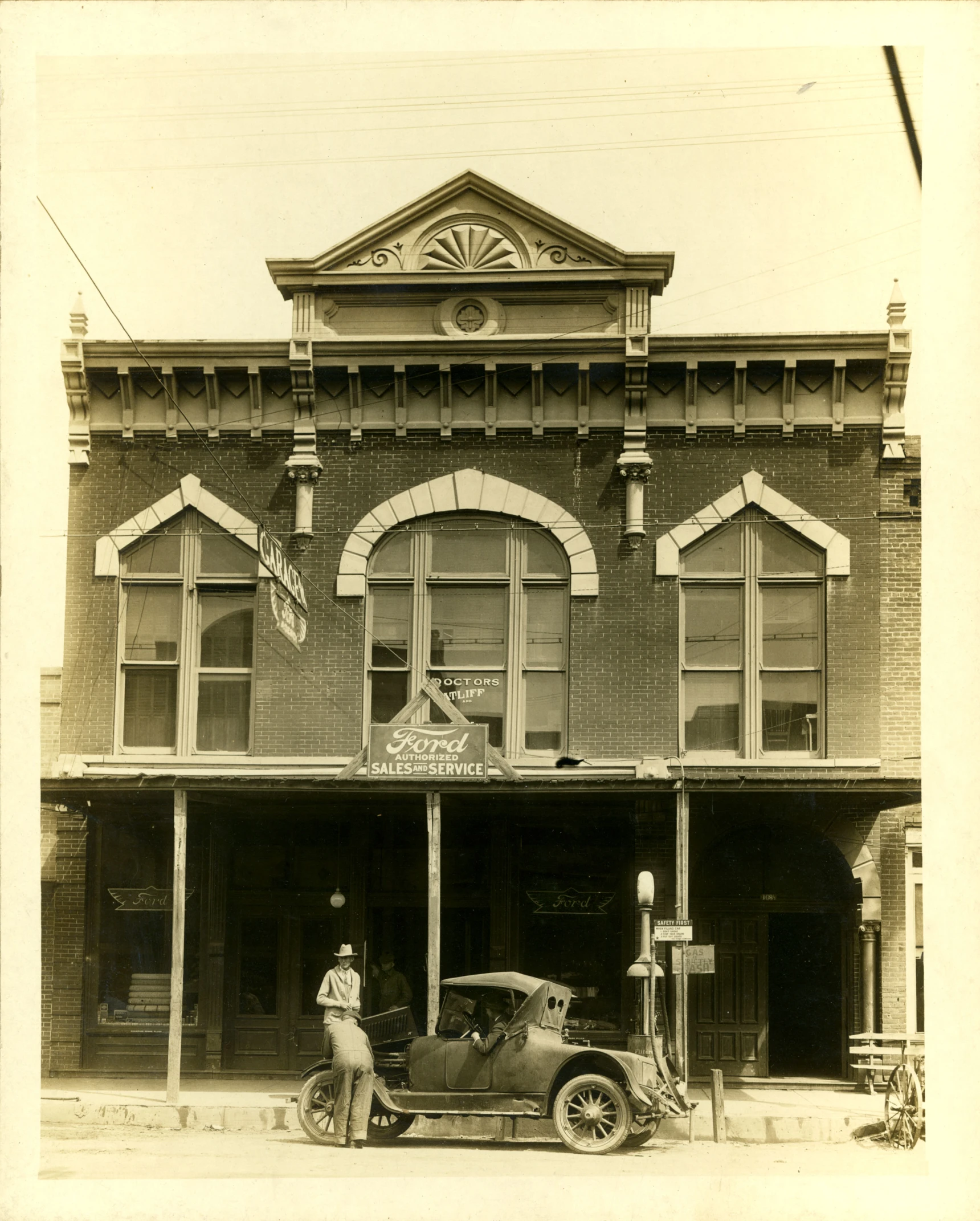 an old po of a building with a car in front