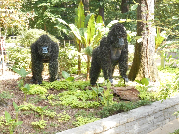 two large animals made out of bushes in the woods