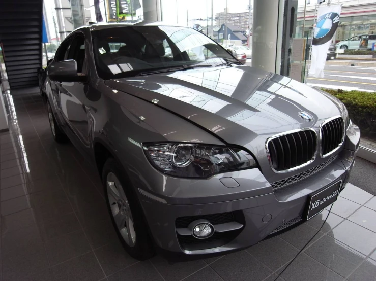 a silver bmw suv in a showroom