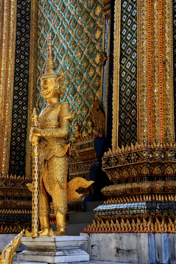 gold statue in front of intricately colored columns