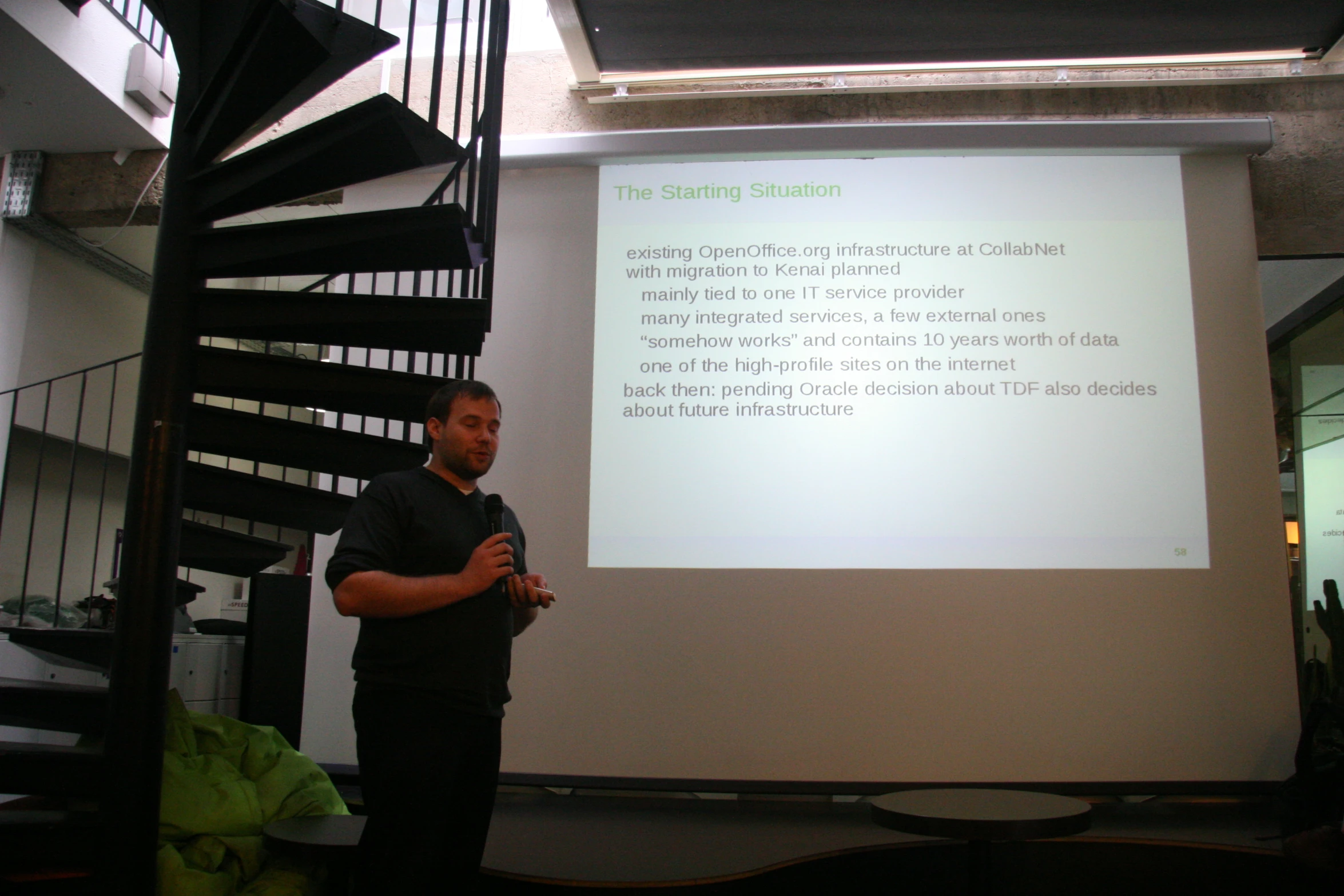 a man standing in front of a projection screen in a room