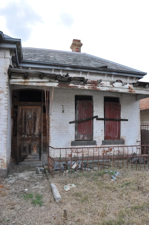 an old run down house with two broken doors