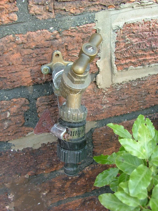 an old faucet standing on a brick sidewalk