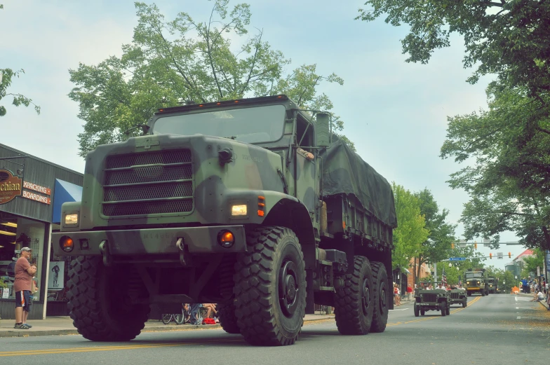 a large camouflaged vehicle driving down the street