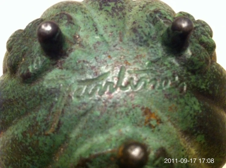 close up of a green object with black rivets