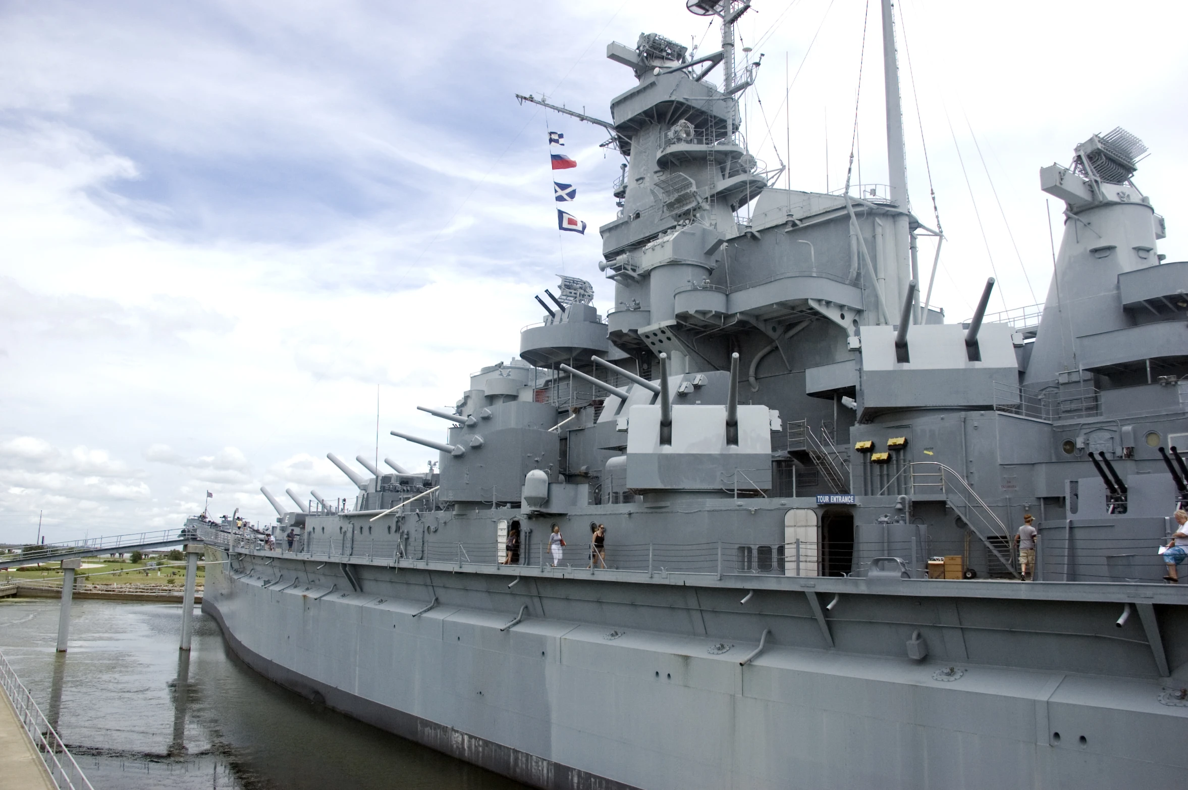 a large battleship with flags sticking out of the side of it