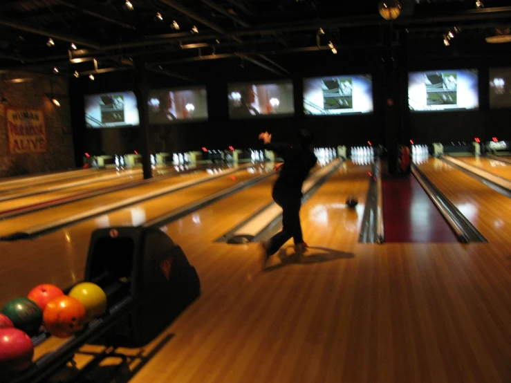 bowling alley with lanes for bowling balls and a bowling player
