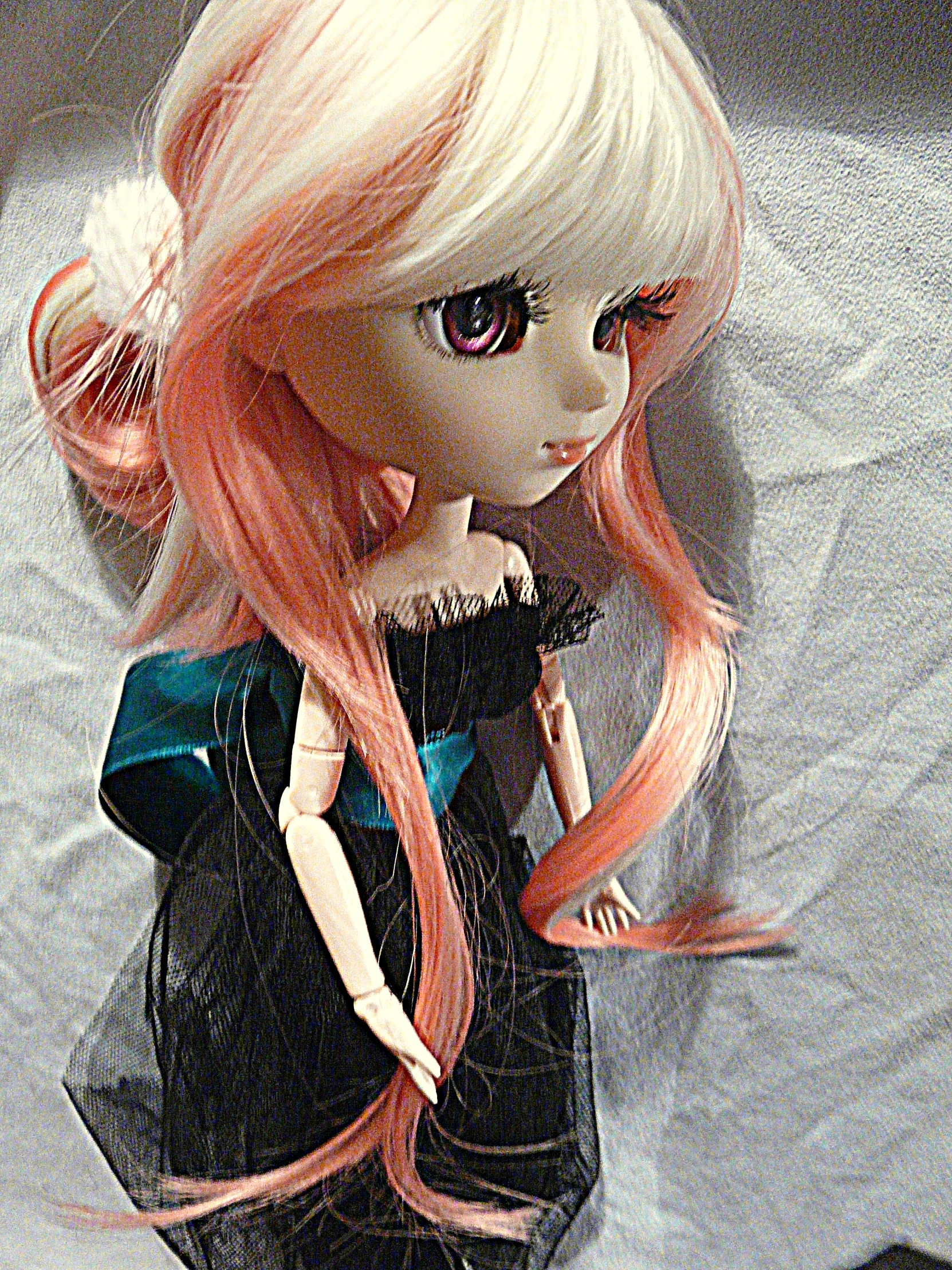 a pink doll with blonde hair standing in a room