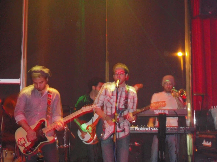 two men are standing behind an electronic keyboard on stage