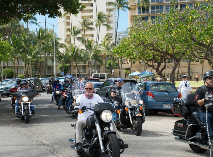 motorcyclist and car on street with other motorcycles in distance