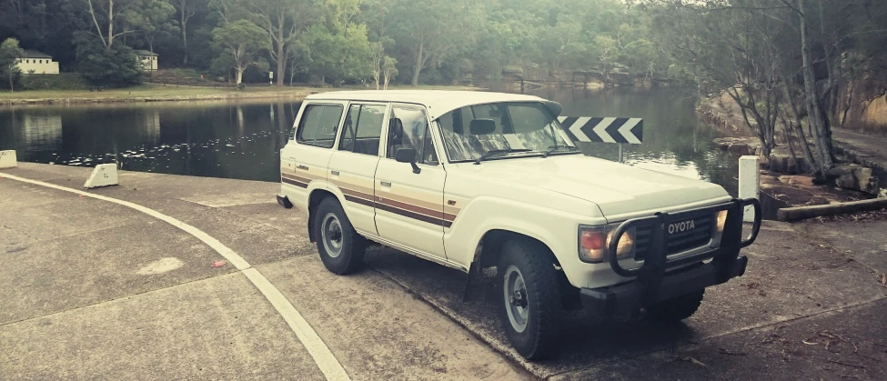 a parked pickup truck in front of some water