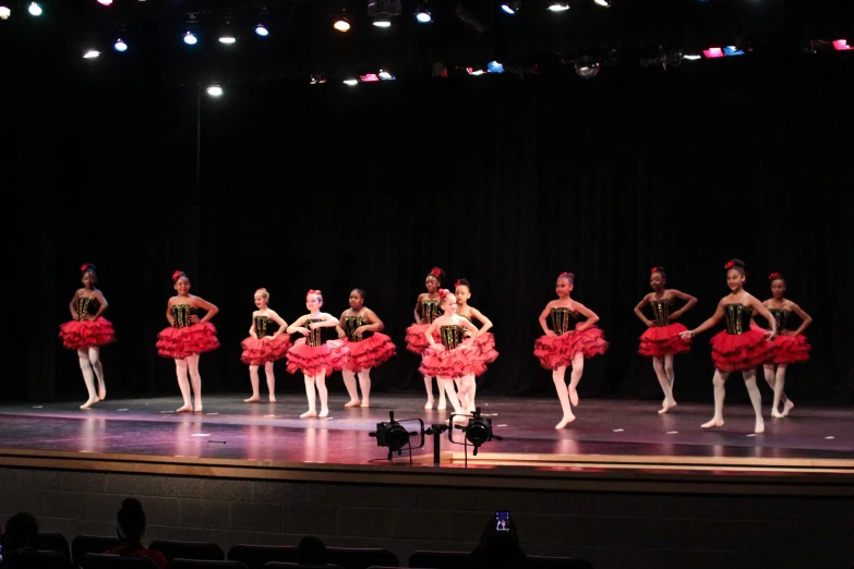 several ballet students stand on a stage in a show