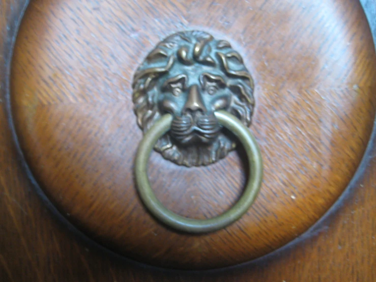 an antique knockk is adorned with a lion head