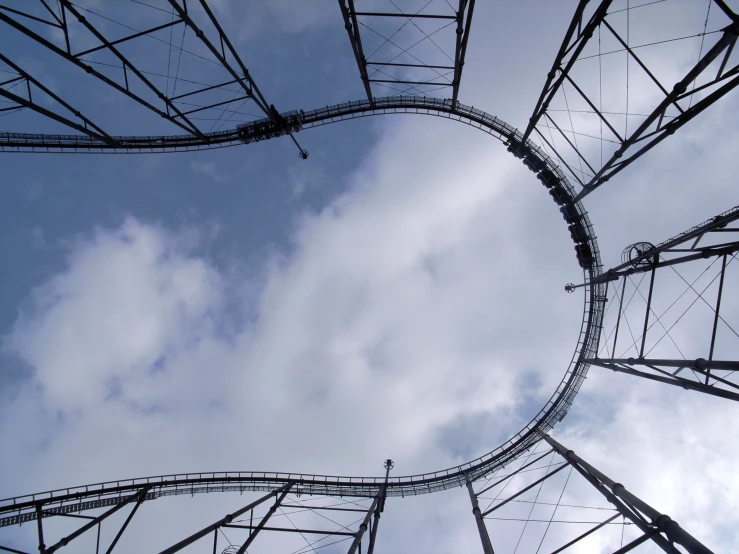 several roller coasters in motion under the cloudy sky