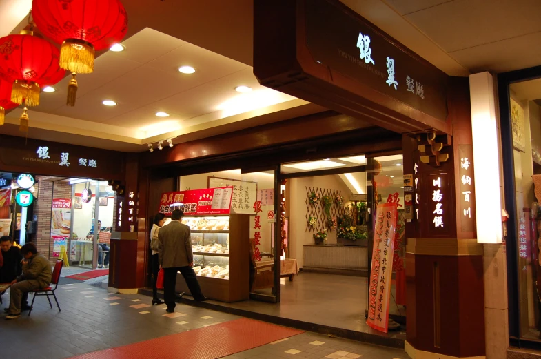 an oriental restaurant has lights above and lanterns over the entrance