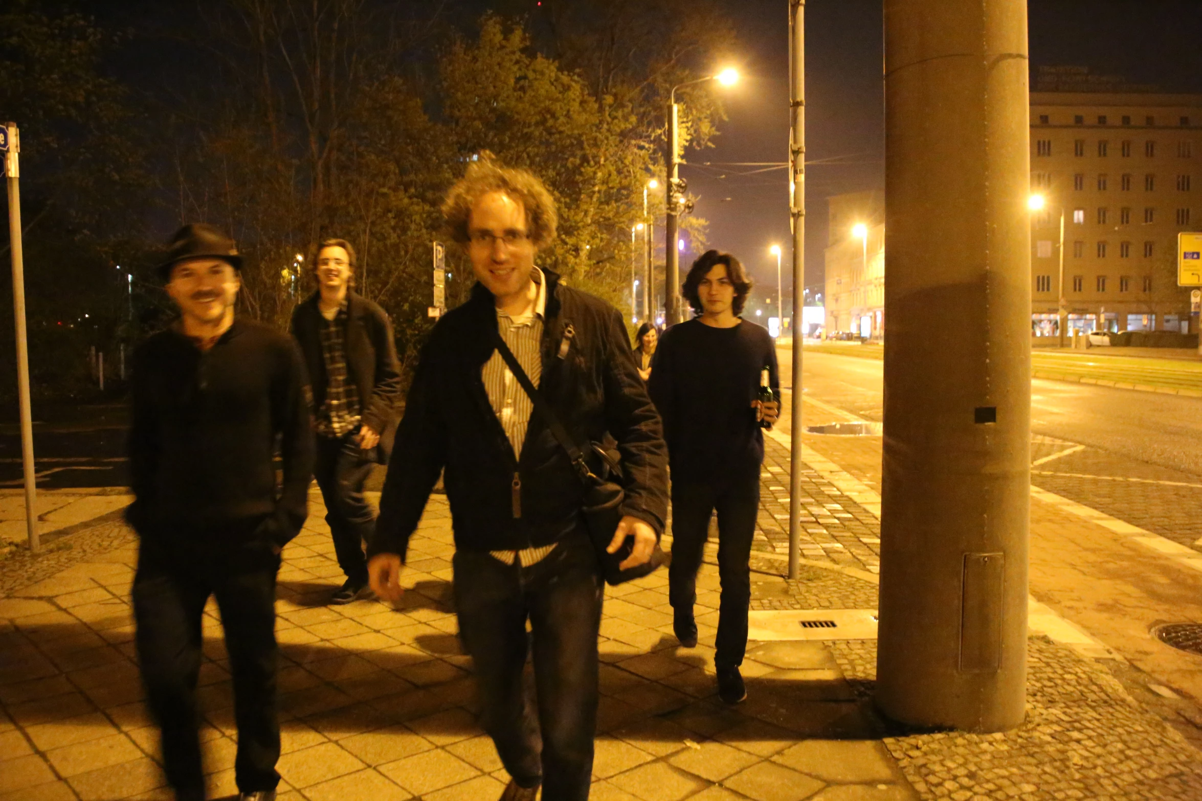 men walking down the sidewalk in the evening