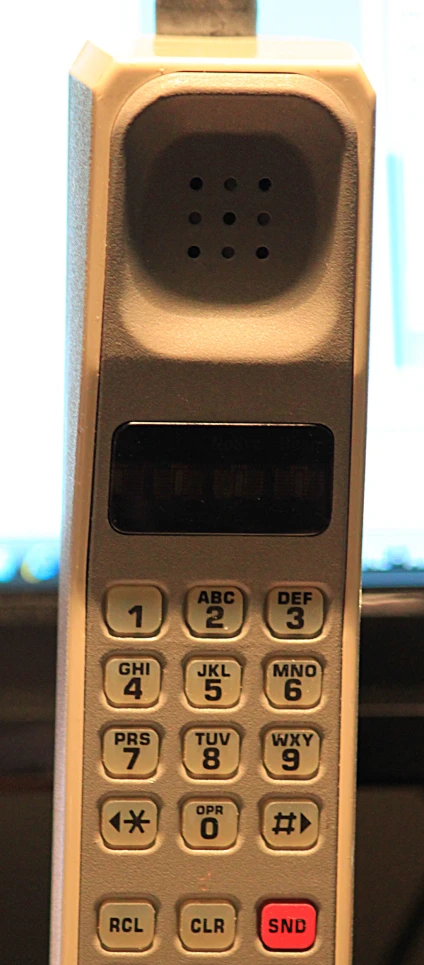 a remote control with a red on next to a keyboard