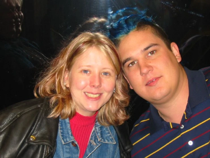 a man and woman smile as they stand together