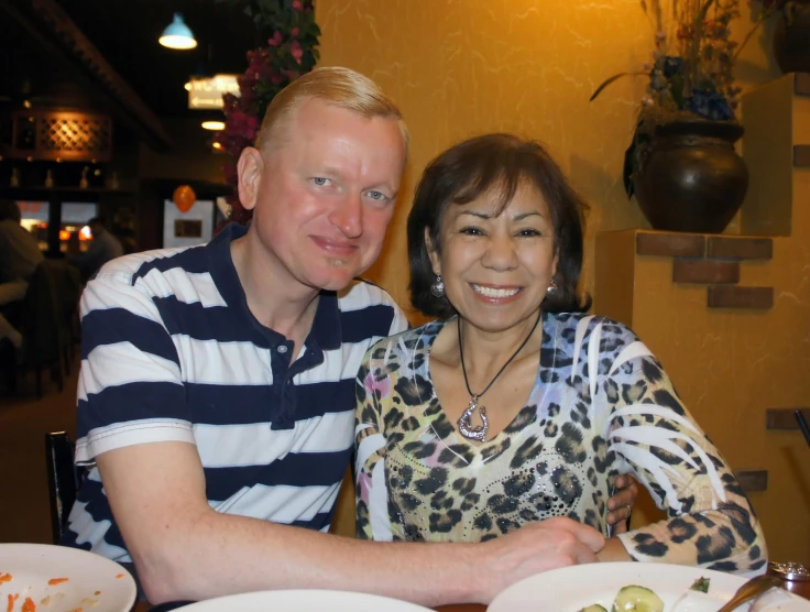 a man and a woman posing for the camera at a restaurant