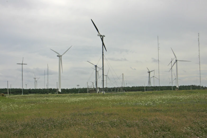 a group of windmills sitting on top of a green field