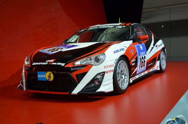 a rally car with numbers on the front sits on a display area