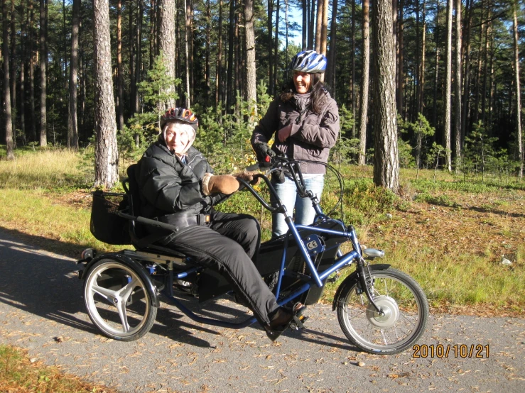 a man sitting in an adult on a cart with another person standing near them