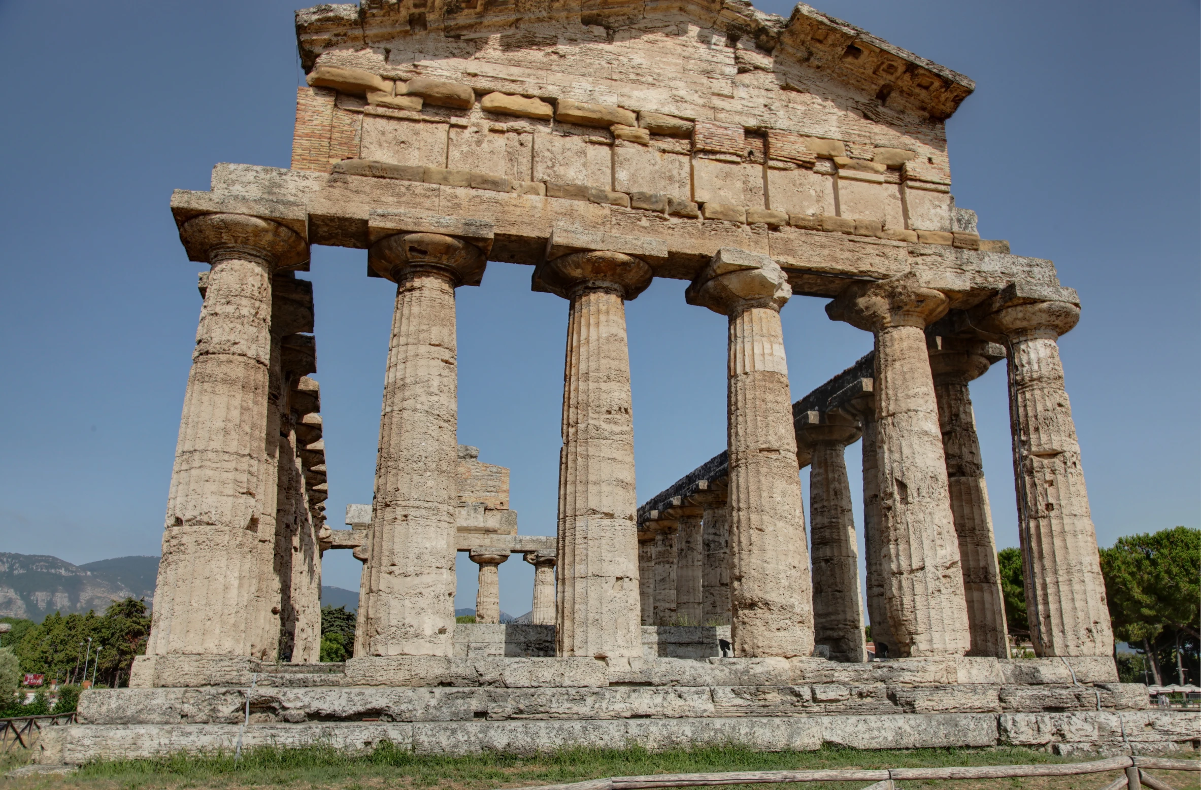 an old temple with several pillars, sitting under a blue sky