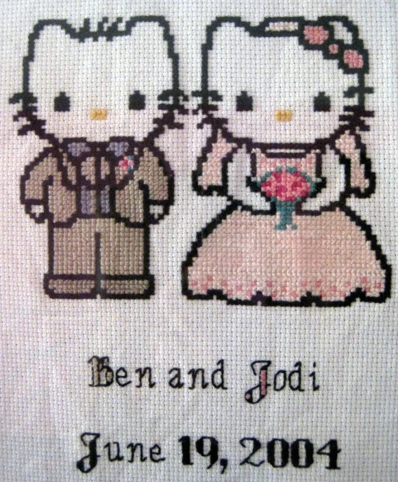 a cross - stitch picture of two cats dressed as a bride and groom