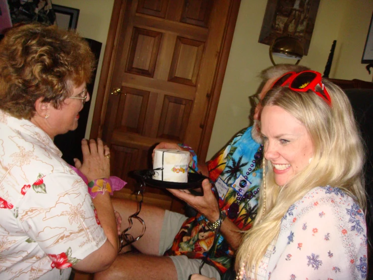 woman getting ready to eat a cake while two other women watch