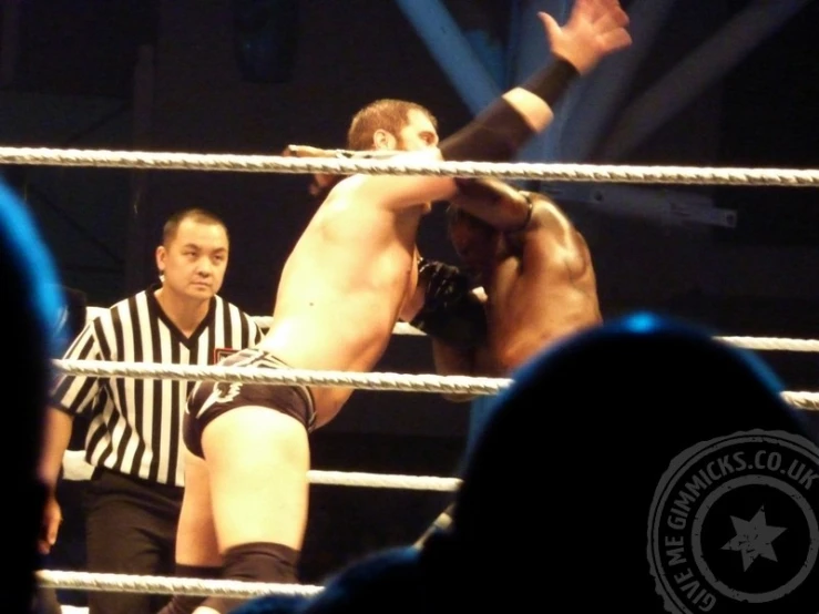 a wrestler is holding his hands up to the belt