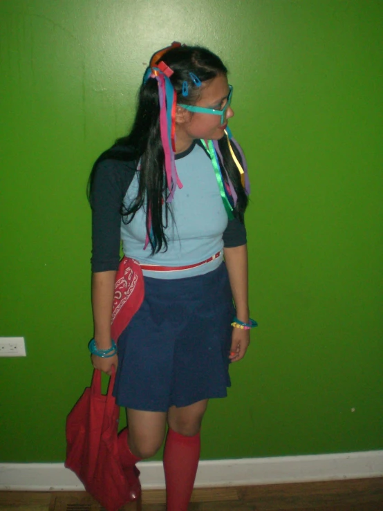 a girl dressed up in schoolgirl clothes and holding red bags and wearing large plastic eye glasses