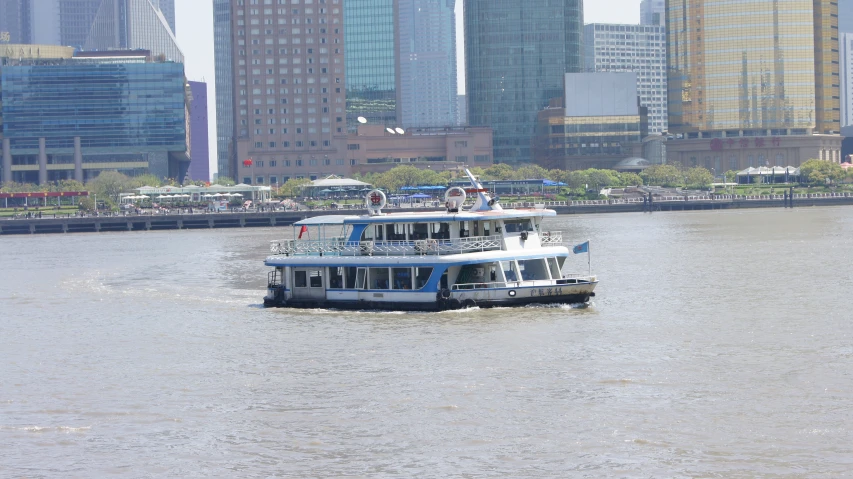 two boats are sailing in the water along a city skyline