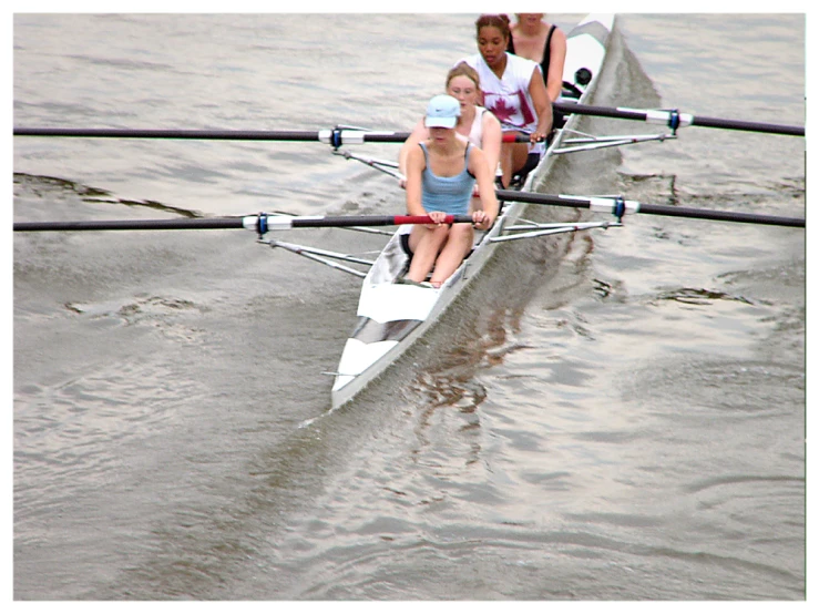 a group of rowers row along the water