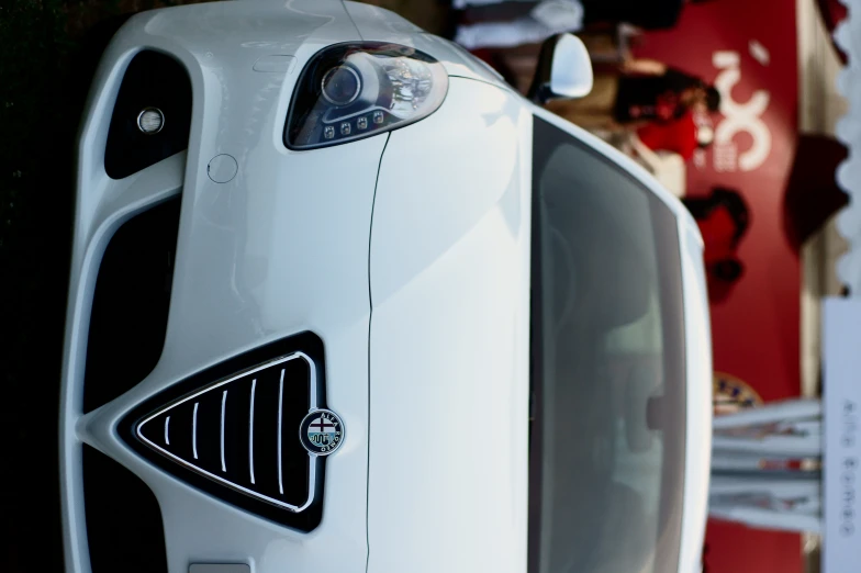 the front view of a white car on display