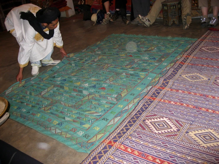 a man tying a rug on the floor