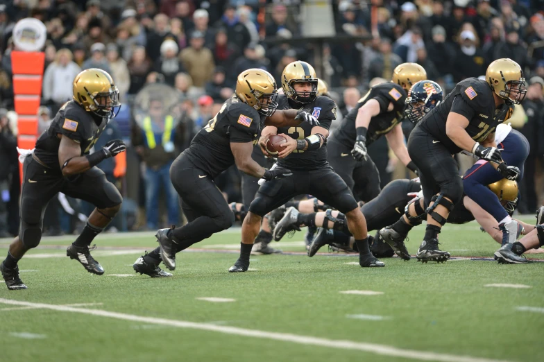 a football game in progress with the ball being picked by three opposing teams