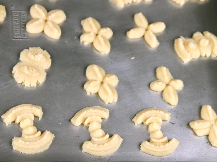 a pan containing some uncooked cookies that have been cut out