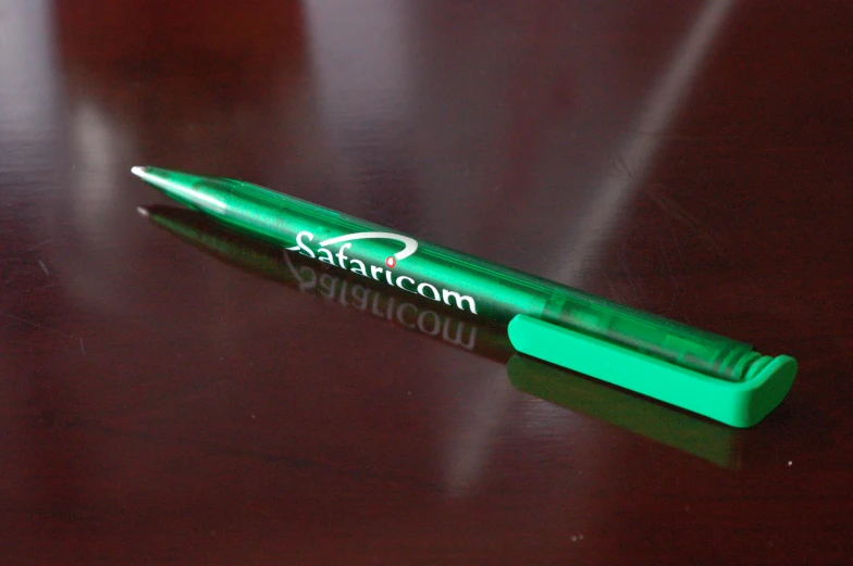 green pens sitting on top of a wooden table