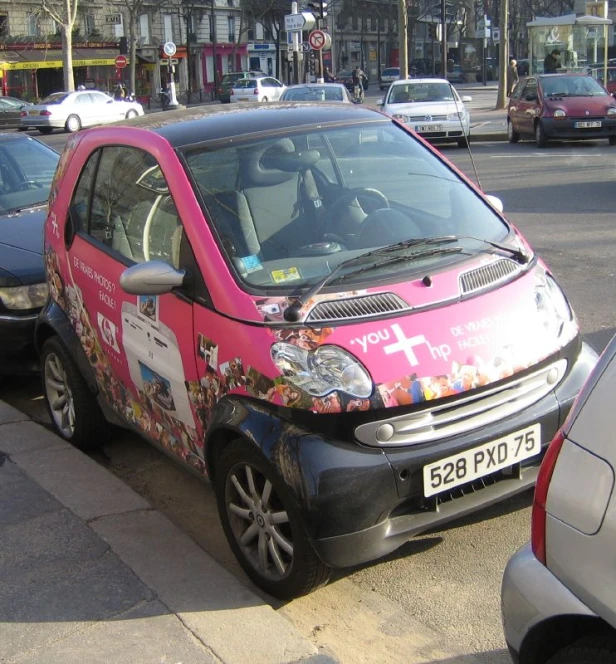 a pink car with flowers painted on the front of it