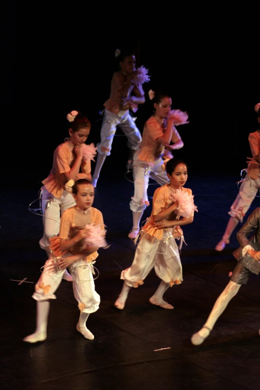 children and adults dance on a stage with one child on his back