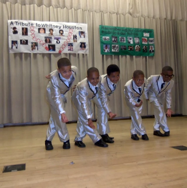 a group of young children with white and silver suits