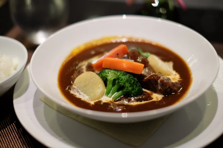 the bowl has many vegetables in it next to a spoon