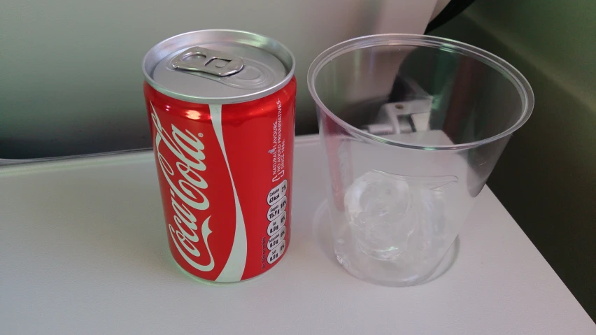 a coke can and glass on top of a table