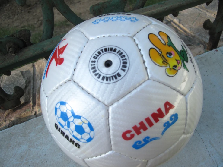 a white soccer ball with logos painted on it